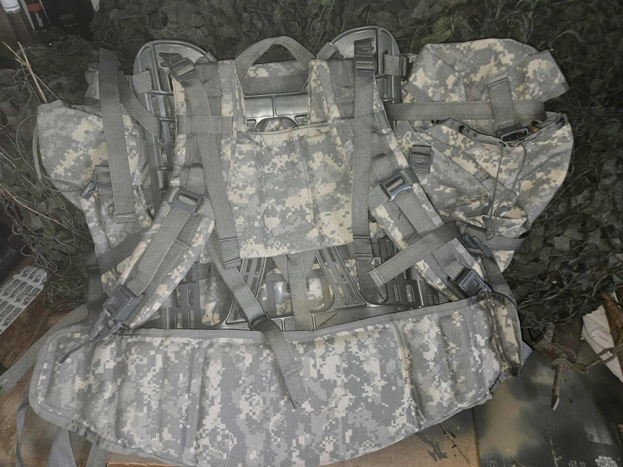 Camouflage tactical vest with straps on a grassy background